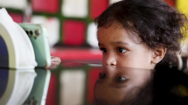 child Intensely concentrated on mobile phone screen indoor close up