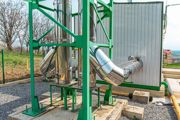 An industrial heating system features shiny stainless steel exhaust pipes supported by a green...