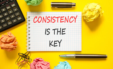 Consistency is the key symbol. Concept words Consistency is the key on beautiful white note. Beautiful yellow background. Black pen. Business consistency is the key concept. Copy space.