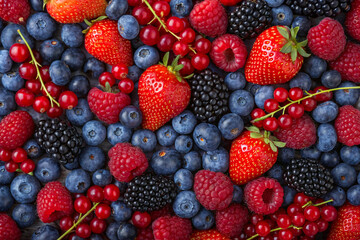 Vibrant mix of fresh summer berries on white background.