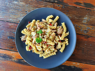 Pasta. Chilli, Garlic, Olive Oil, Italian Sausage with Fusilli, A mildly spicy flavor on a wooden table. Top view of Italian food
