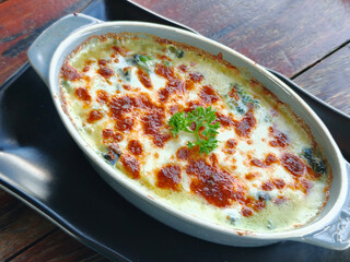 Side view of Baked spinach with cheese on a wooden table. Italian food