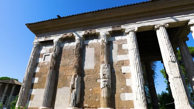 temple portunus displays weathered ionic columns patchwork stone fa&ccedil;ade circular hercules victor visible background under bright blue sky rome italy of 