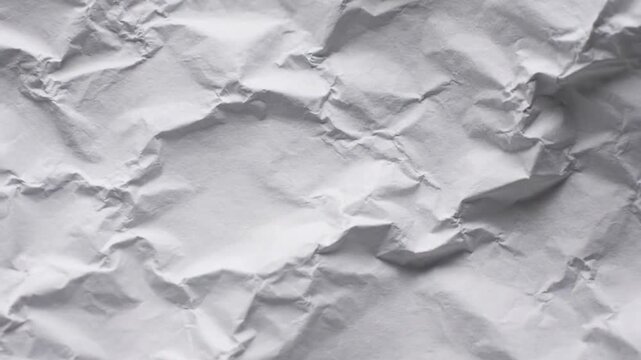 Abstract background of crumpled white paper texture, featuring intricate folds, creases, and shadows creating a dynamic and expressive surface