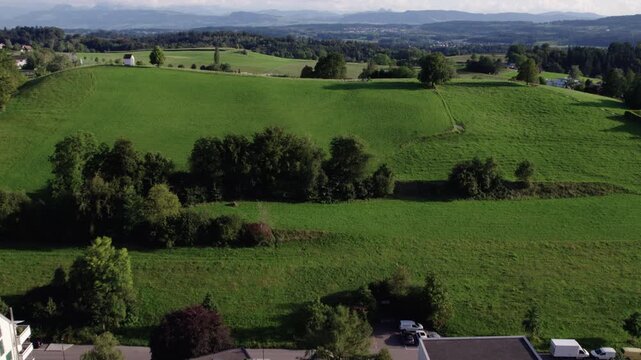 Revealing a green hill with a small white house on top, Uster, Switzerland