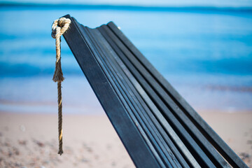 Close-up of Wooden Beach Chair Backrest with Rope Knot on Sandy Shore at Isosaari during Finnish Archipelago Summer © Henri Heilala