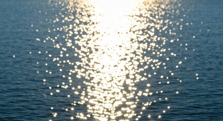 Sun's reflection shimmering on calm, dark water; bokeh effect