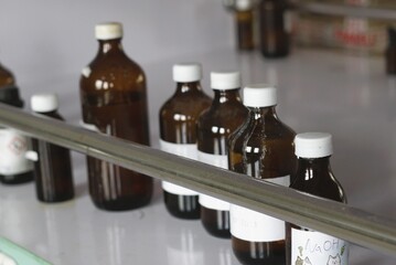 amber glass chemical reagent bottles with white caps in a laboratory setting