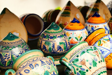 Traditional handcrafted pottery displayed in a vibrant assortment of shapes and colors, showcasing decorative patterns and rich artisanal detail characteristic of Mediterranean ceramic craftsmanship