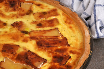 Vue partielle d'une tarte au camembert faite maison entam&eacute;e dans un plat en gros plan
