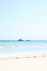 Obraz premium Small motorboats float on clear blue water near a sunny sandy beach shore