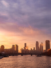 Fototapeta premium London cityscape at sunset, Thames river flowing under historic bridge with modern skyline and vibrant sky