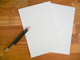 Blank Textured Paper Sheets with Pencils on Wooden Desk