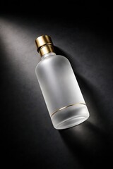 Luxurious frosted glass bottle with gold cap and base on a dark background with dramatic studio lighting.
