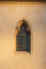Fototapeta premium Gothic arch window on church facade at night
