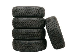 four black, textured, off-road truck tires stacked vertically, with one tire lying horizontally in front.