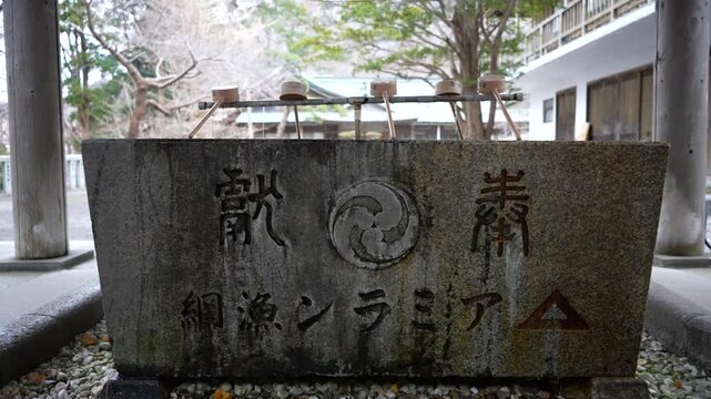 Stone washing basin detail in Hachimangu Shrine Hakodate Japan. Medium shot