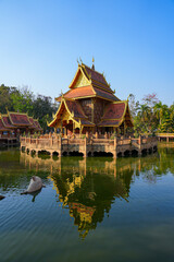 Fototapeta premium Traditional Lanna pavilion reflected in the sacred pond of Wat Phra That Pha Ngao temple in Chiang Saen, Northern Thailand