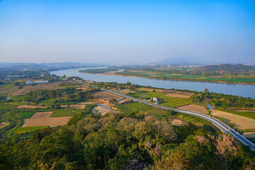 Aerial landscape of the fertile plains and river curves of the Mekong River valley and international borders at the Golden Triangle in Chiang Saen, Northern Thailand