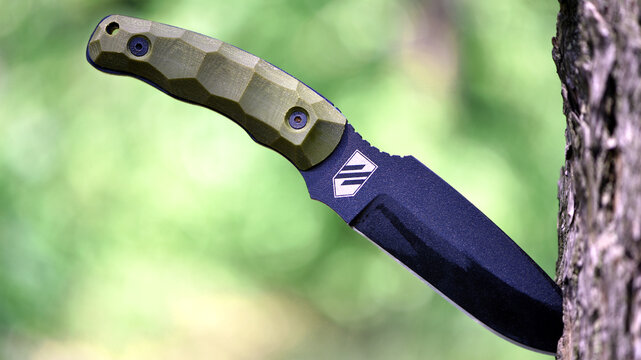 Ukraine, Kyiv. 20.06.2024. combat knife. the knife will stick in the tree. Azov emblem. black blade. tactical ammunition. Ukrainian stormtrooper knife. steel arms. sharp blade, close-up. editorial