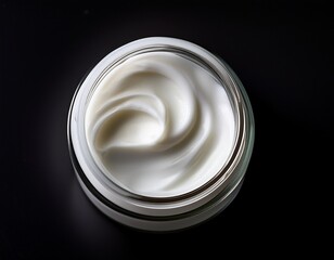 white cream in a clear jar on a black background