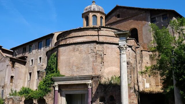 ancient roman brick rotunda small domed cupola cross beside medieval buildings lone marble column creeping greenery tempio del divo romolo close view rome italy empire emperor 