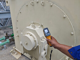 Technician using a thermal imaging camera to inspect an industrial motor and ventilation system, detecting heat patterns for preventive maintenance, safety monitoring, and equipment reliability.