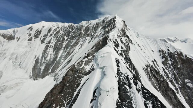 Steep rocky ridge and snow cornices. Drone flight to Gorky Peak, Kyrgyzstan. 4K