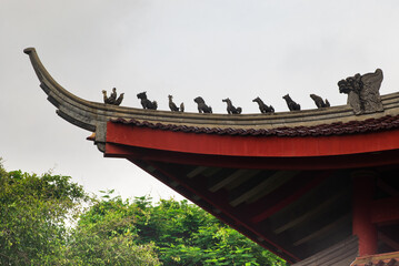 Traditional Chinese Temple Roof with Ornamental Statues Against Sky