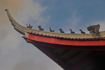 Chinese Temple Roof with Mythical Animal Statues Against Blue Sky