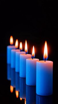 Bluecandlesinarow,glowingonblackbackground.