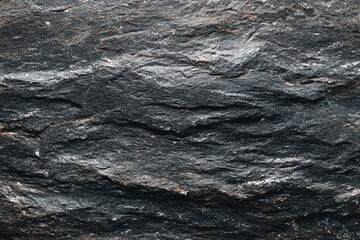 Fototapeta premium dark grey textured rock surface with subtle brown and white mineral veins