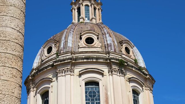 daytime domed baroque church facade arched windows stone statues spiral relief column rises beside under clear blue sky rome view italy roman empire emperor fa ade 
