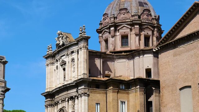 sunlit ornate baroque church weathered stone dome sculpted facade layered architecture stands against vivid blue sky rome view italy roman empire emperor fa ade details 