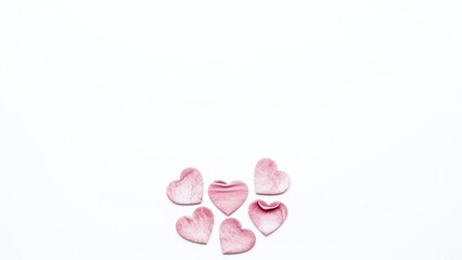 Obraz premium Delicate pink hearts on white background, creating romantic atmosphere with soft lighting and gentle color palette
