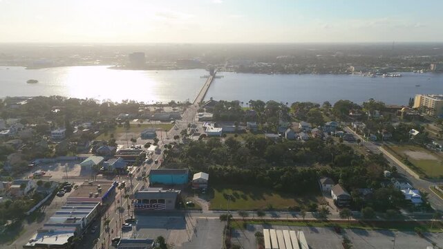 Aerial drone view over Daytona Beach Florida with residential neighborhoods main road bridge and Halifax River on clear sunny day