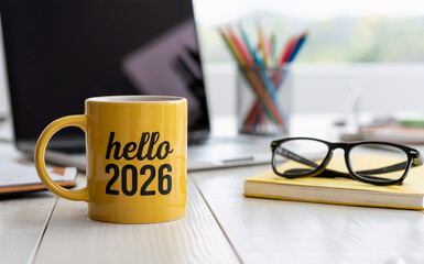 Yellow Coffee Mug with Hello 2026 Text on Office Desk for New Year Concept