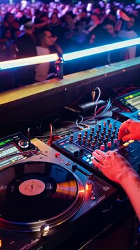 A DJ Skillfully Blends Beats and Melodies at an Energetic Nightclub, Capturing the Essence of Live Music and Entertainment Through Professional Equipment and Lighting