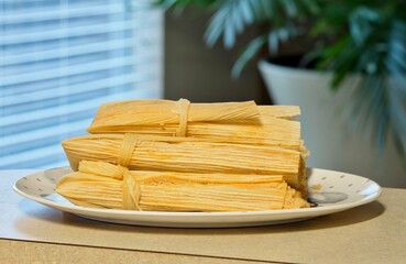 Fresh tamales on plate Mexican food Hispanic cooking domestic household countertop.