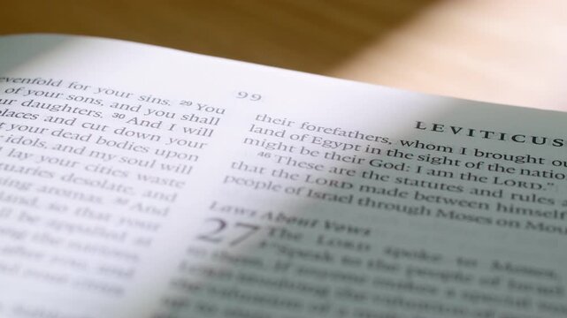 Macro video of Bible pages turning from Leviticus to Numbers books. Clean typography print, soft lighting, English standard version. Ideal for Christian, spiritual, or educational content. 4K close up