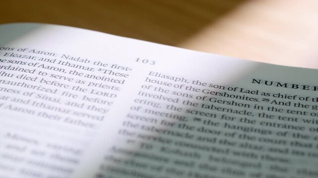 Macro video of Bible book of Numbers with pages turning in Old Testament. Clean typography, soft lighting. Ideal for Christian, spiritual, or christian educational content. 4K close up slide left