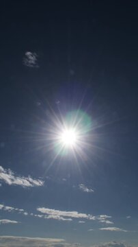 Clouds passing in a blue sky with the sun. Time Lapse. 4K Vertical