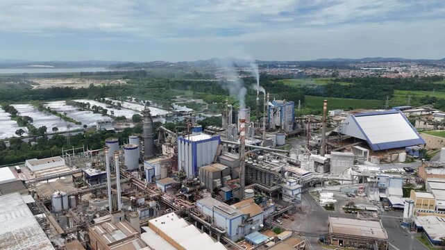 &Aacute;rea industrial dedicada &agrave; produ&ccedil;&atilde;o de papel e celulose com m&aacute;quinas de grande porte, caldeiras e chamin&eacute;s integradas, representando industrializa&ccedil;&atilde;o e desafios ambientais.