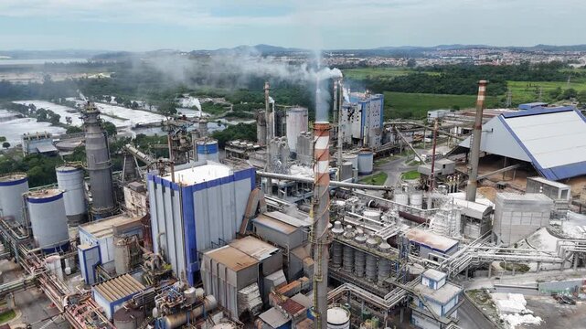 V&iacute;deo a&eacute;reo de ind&uacute;stria de papel e celulose mostrando chamin&eacute;s, caldeiras e produ&ccedil;&atilde;o industrial em larga escala, com foco em impacto ambiental e infraestrutura pesada.