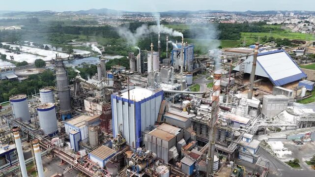 Vis&atilde;o a&eacute;rea drone v&iacute;deo 4k ind&uacute;stria de papel e celulose em alta produ&ccedil;&atilde;o industrial com vista das caldeiras, chamin&eacute;s e planta industrial