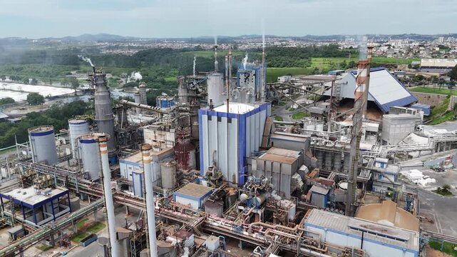 Vis&atilde;o a&eacute;rea de f&aacute;brica de papel e celulose destaca caldeiras, chamin&eacute;s e sistemas produtivos integrados, representando a complexidade e a efici&ecirc;ncia da produ&ccedil;&atilde;o industrial moderna.