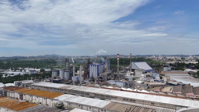 Vista a&eacute;rea de f&aacute;brica de papel e celulose com caldeiras, chamin&eacute;s e estruturas industriais, representando a infraestrutura necess&aacute;ria para produ&ccedil;&atilde;o cont&iacute;nua em larga escala.