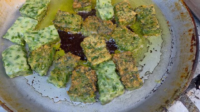 Golden garlic chive dumplings, a well-known Chinese and Thai street snack, sizzling as they are pan-fried in a wok.