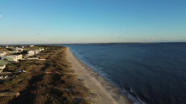 Aerial view of beach front homes and dunes in Oak Island, North Carolina