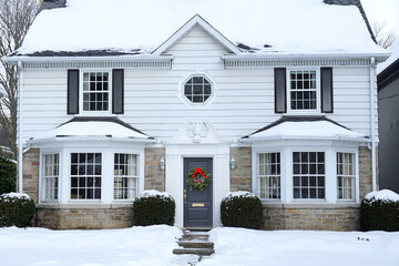 Traditional two story middle class house covered in snow